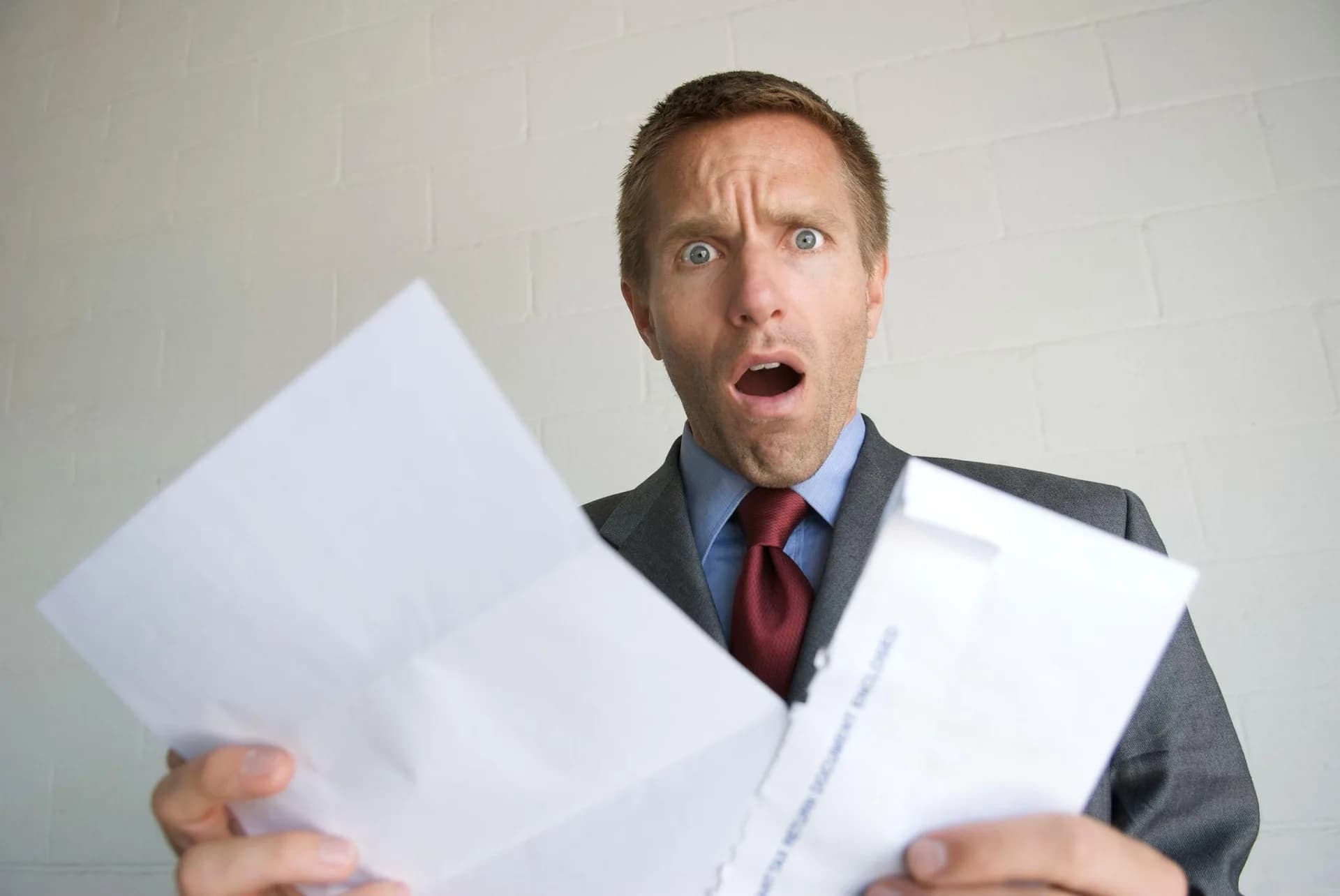 Mann erschrocken hält Brief