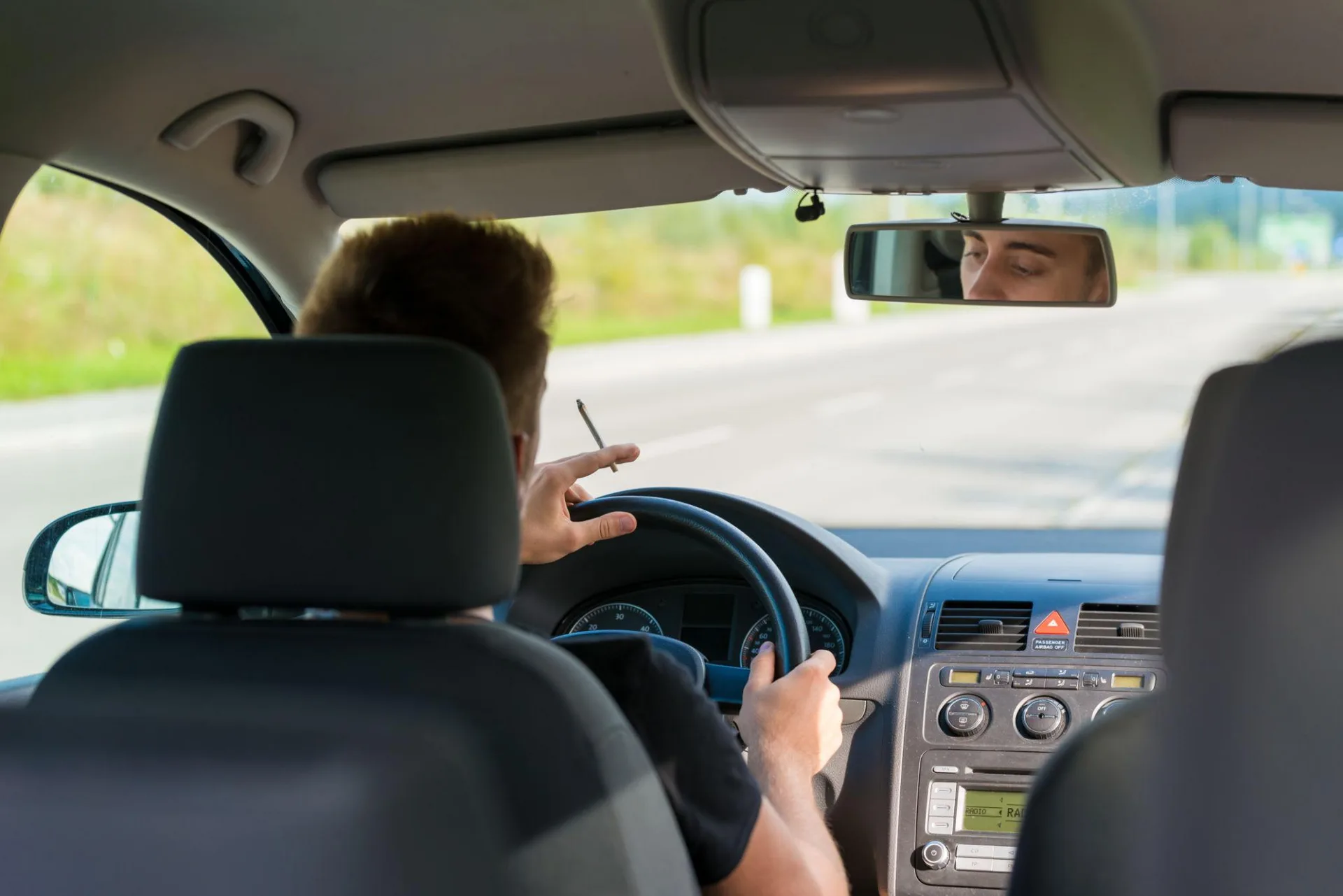 Mann raucht beim Fahren