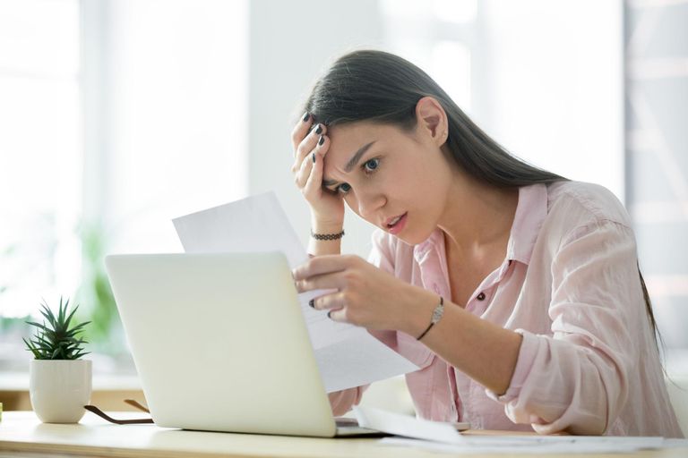 Frau liest Brief vor Laptop